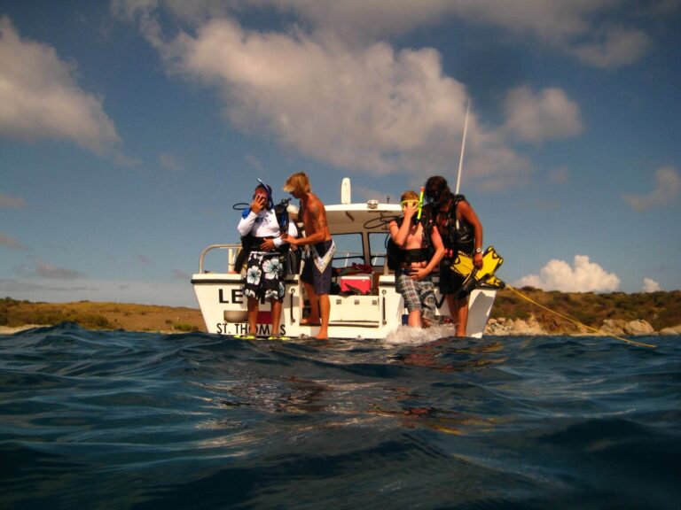 a group of people riding on the back of a boat in the water